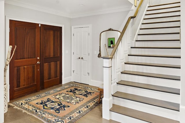 foyer with stairway, crown molding, baseboards, and wood finished floors