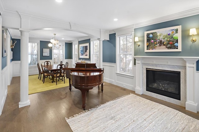 interior space featuring a fireplace, wood finished floors, and ornate columns