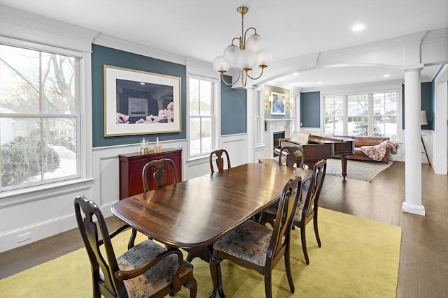 dining area featuring decorative columns, a fireplace, and a healthy amount of sunlight