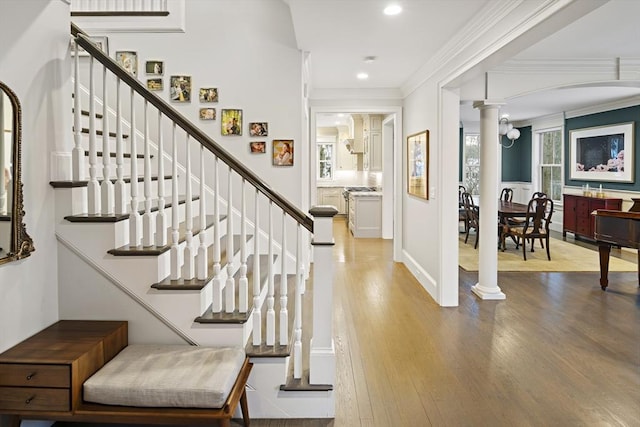 entryway featuring recessed lighting, decorative columns, wood finished floors, and ornamental molding