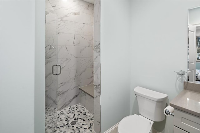 full bath featuring vanity, toilet, and a marble finish shower