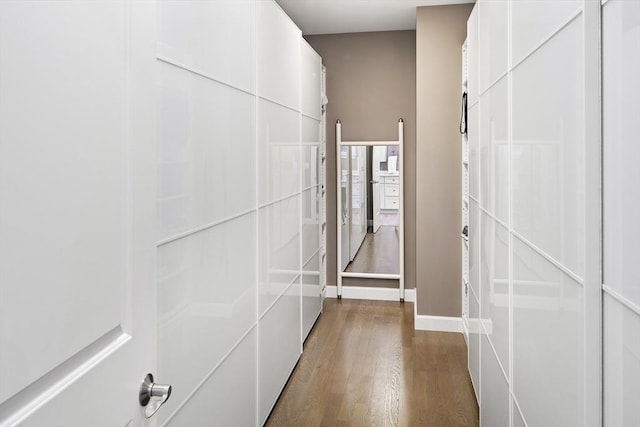 hall with dark wood-type flooring and baseboards