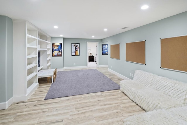 living area with recessed lighting, baseboards, and light wood finished floors