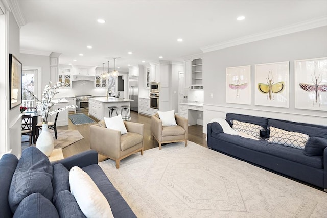 living room with crown molding, recessed lighting, and light wood-type flooring