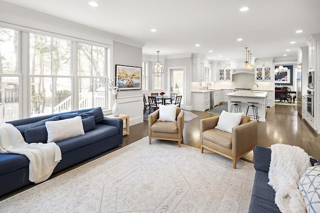 living area with crown molding, recessed lighting, and dark wood-style floors