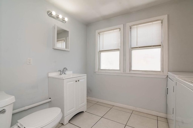 bathroom featuring tile patterned flooring, baseboards, washer and clothes dryer, toilet, and vanity