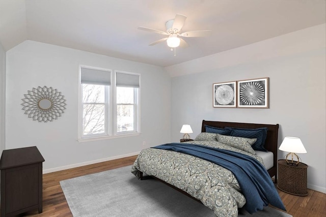 bedroom with baseboards, wood finished floors, and vaulted ceiling