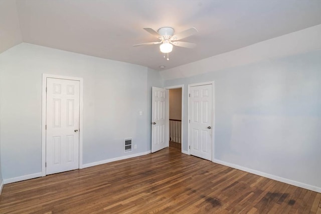 unfurnished bedroom featuring visible vents, baseboards, lofted ceiling, and wood finished floors