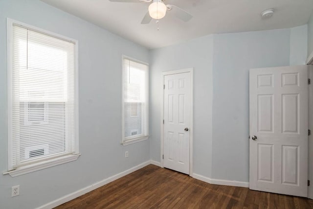 unfurnished bedroom with a ceiling fan, dark wood-style floors, and baseboards