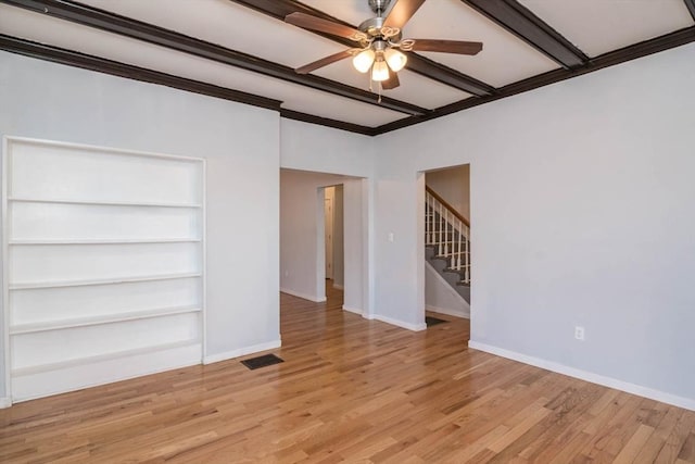 spare room featuring visible vents, baseboards, light wood-style floors, and stairs