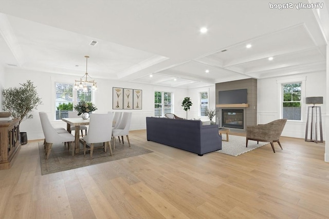 living room featuring beamed ceiling, coffered ceiling, a notable chandelier, and light hardwood / wood-style floors