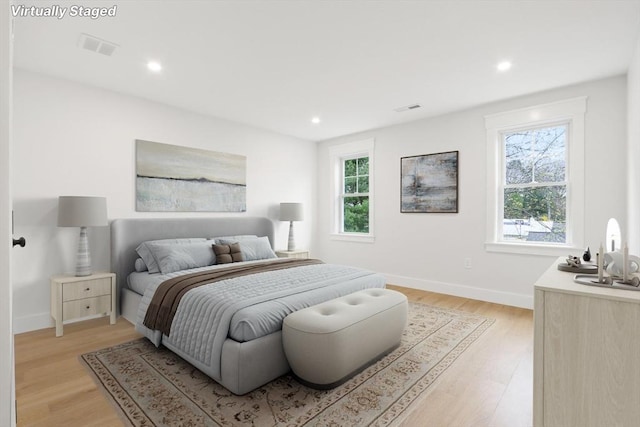 bedroom with multiple windows and light hardwood / wood-style floors