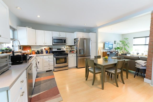 25 Taft St Unit 25, North Adams, MA 01247 - kitchen with appliances with stainless steel finishes, light wood-type flooring, a sink, white cabinetry, and light countertops