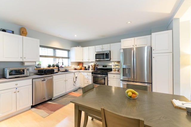 25 Taft St Unit 25, North Adams, MA 01247 - kitchen featuring appliances with stainless steel finishes, a sink, white cabinets, recessed lighting, and light countertops
