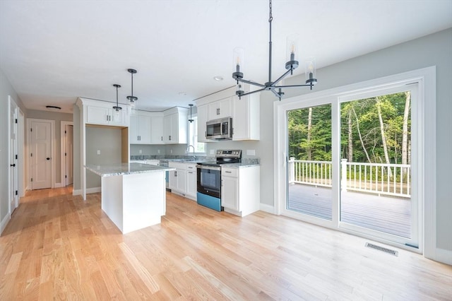 142 Tispaquin St, Middleboro, MA 02346 - kitchen featuring appliances with stainless steel finishes, a chandelier, a sink, white cabinetry, and light wood finished floors