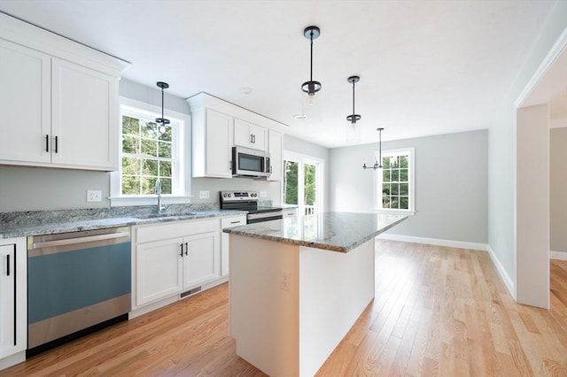 142 Tispaquin St, Middleboro, MA 02346 - kitchen with stainless steel appliances, a sink, light wood finished floors, and light stone countertops