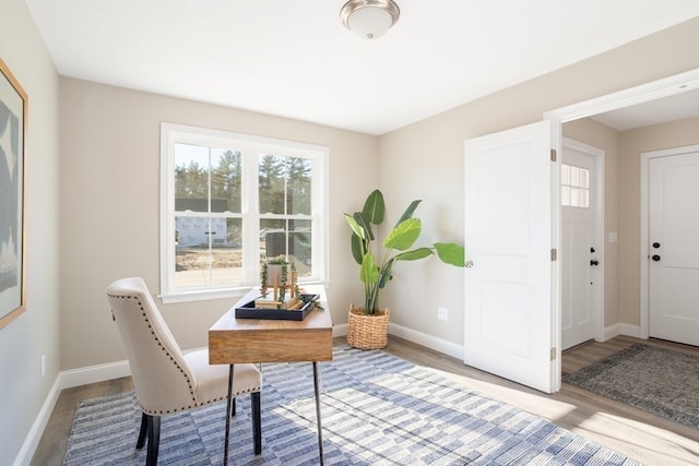 home office with a healthy amount of sunlight and hardwood / wood-style floors