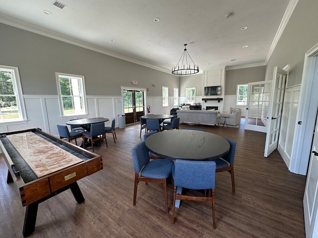 dining space featuring ornamental molding, dark wood-type flooring, and plenty of natural light