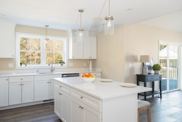 kitchen with dark hardwood / wood-style floors, a center island, sink, and white cabinetry