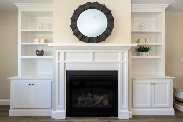 interior details with built in shelves and dark hardwood / wood-style flooring