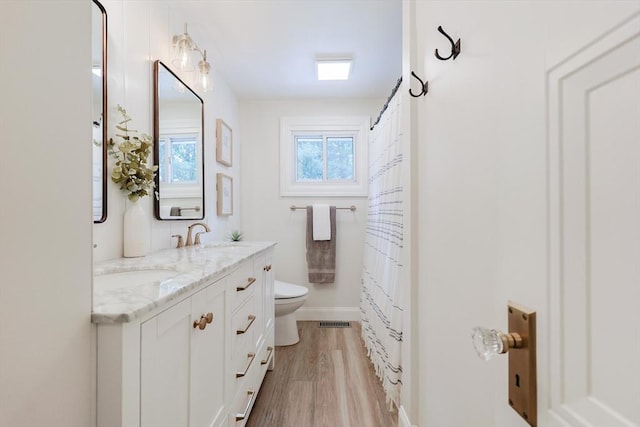 29 Regal St, Holliston, MA 01746 - bathroom with toilet, double vanity, wood finished floors, and curtained shower