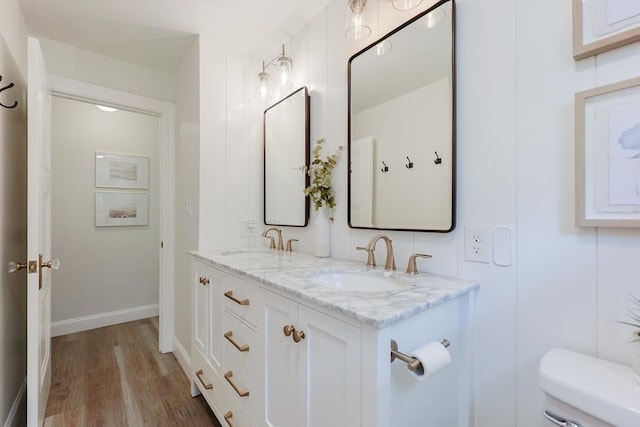 29 Regal St, Holliston, MA 01746 - bathroom featuring toilet, double vanity, wood finished floors, and baseboards