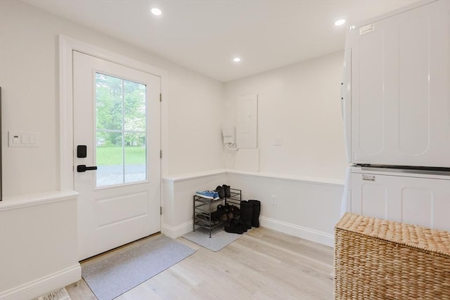 29 Regal St, Holliston, MA 01746 - doorway to outside featuring stacked washing machine and dryer, light wood-type flooring, baseboards, recessed lighting, and electric panel