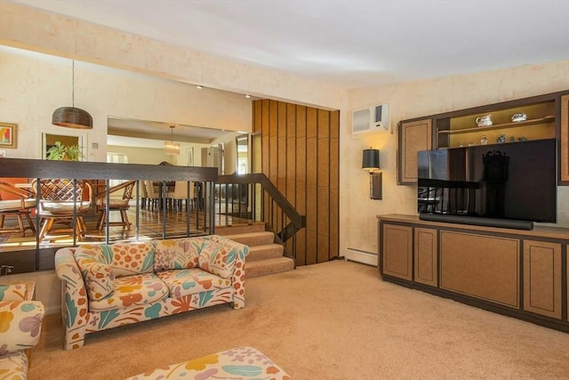 living area featuring light colored carpet, a wall unit AC, baseboard heating, and stairs