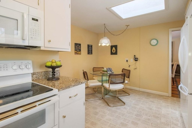 kitchen featuring decorative light fixtures, white appliances, white cabinetry, and baseboards