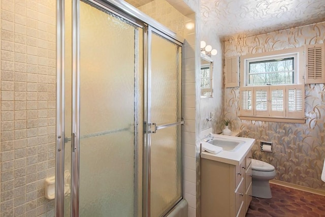 full bathroom with toilet, an enclosed shower, vanity, baseboards, and wallpapered walls