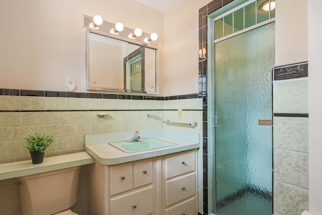 full bathroom with toilet, vanity, tile walls, wainscoting, and a shower stall