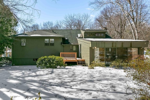 snow covered rear of property featuring a wooden deck