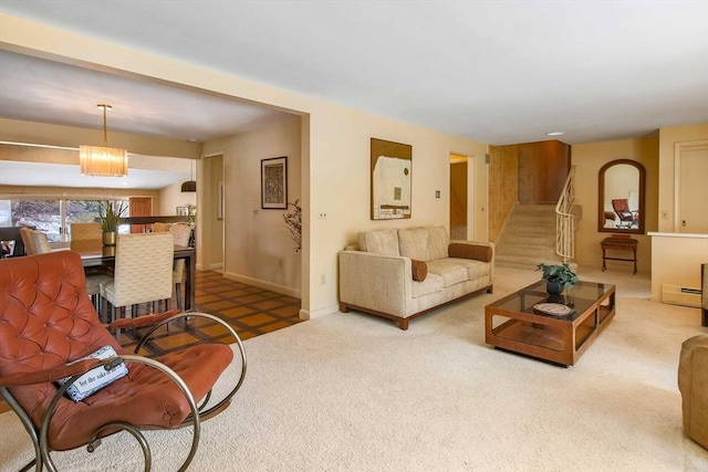 carpeted living area with a baseboard radiator, stairway, and baseboards