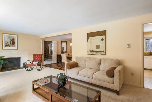 carpeted living room with a fireplace and a sink