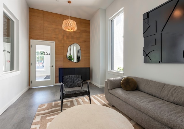 living room featuring wood walls and concrete flooring