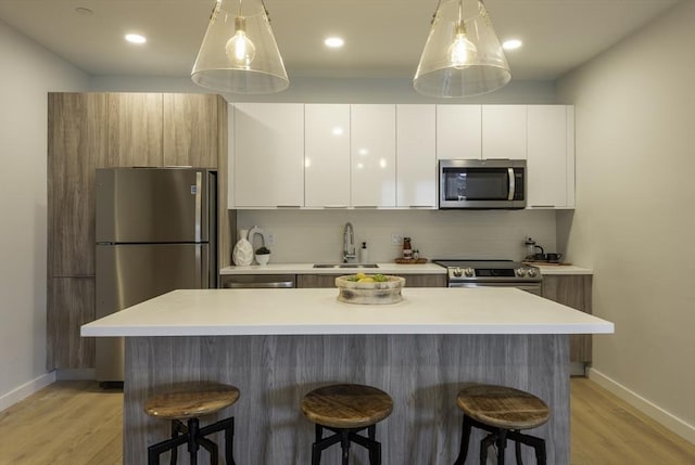 kitchen featuring white cabinets, decorative backsplash, stainless steel appliances, and a center island