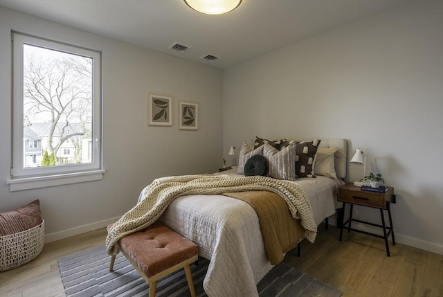 bedroom featuring light hardwood / wood-style floors and multiple windows