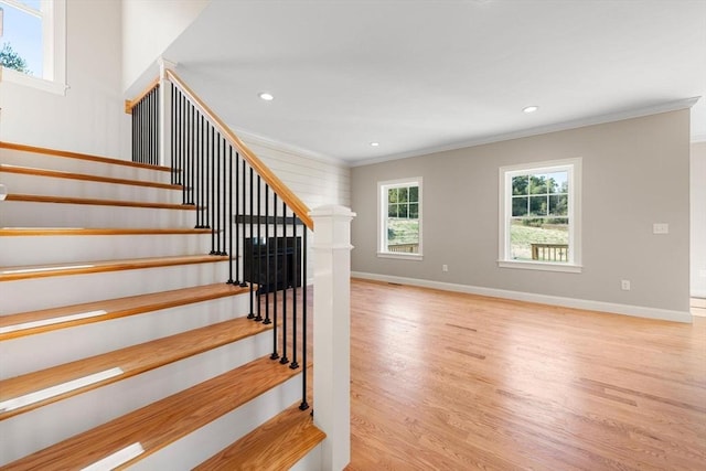 stairway with crown molding and hardwood / wood-style flooring