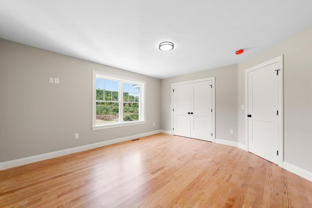 unfurnished bedroom with light hardwood / wood-style floors and a closet