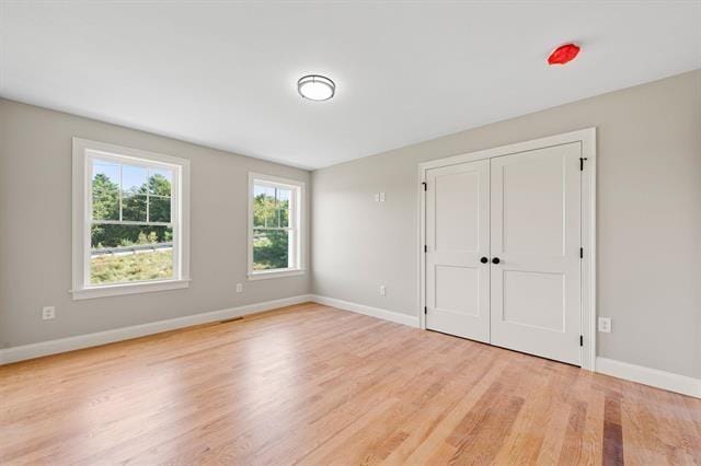 unfurnished bedroom with light hardwood / wood-style flooring and a closet