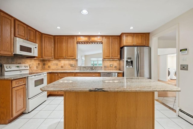 103 Central St, Newbury, MA 01922 - kitchen featuring stainless steel appliances, separate washer and dryer, baseboard heating, light tile patterned floors, and a kitchen island