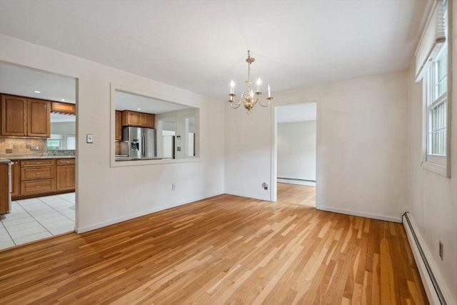 103 Central St, Newbury, MA 01922 - spare room featuring baseboard heating, a chandelier, and light wood-style flooring