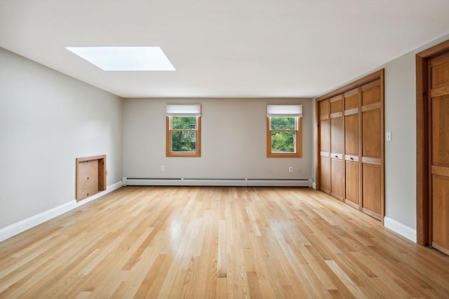 103 Central St, Newbury, MA 01922 - unfurnished bedroom with a baseboard radiator, a skylight, light wood-style floors, and multiple windows