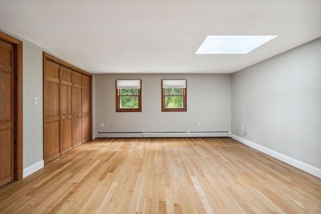 103 Central St, Newbury, MA 01922 - unfurnished bedroom featuring a skylight, light wood-style flooring, baseboard heating, and a closet