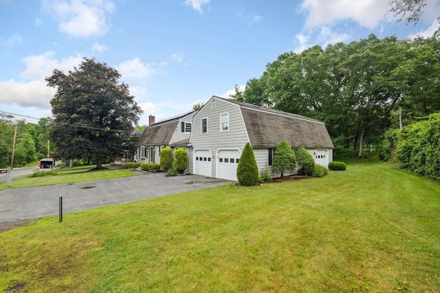 103 Central St, Newbury, MA 01922 - view of side of property with a gambrel roof, driveway, a garage, a yard, and a chimney