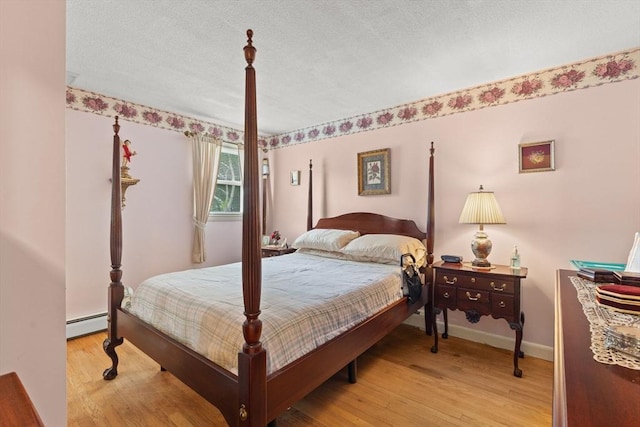 114 Cypress Dr, Swansea, MA 02777 - bedroom with a baseboard heating unit, wood finished floors, and a textured ceiling