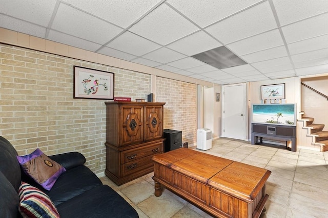 114 Cypress Dr, Swansea, MA 02777 - living area with brick wall, a drop ceiling, stairs, and light tile patterned floors