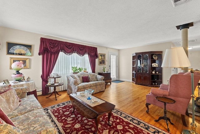114 Cypress Dr, Swansea, MA 02777 - living room with wood finished floors, a baseboard heating unit, and a textured ceiling