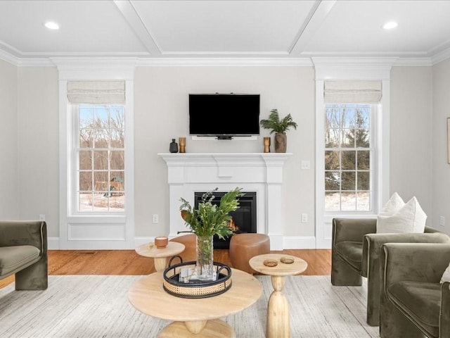 living room featuring light hardwood / wood-style flooring, ornamental molding, and plenty of natural light