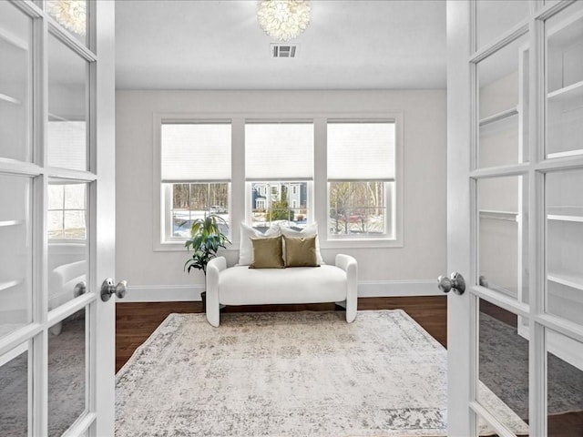 sitting room featuring dark hardwood / wood-style flooring, french doors, and a healthy amount of sunlight